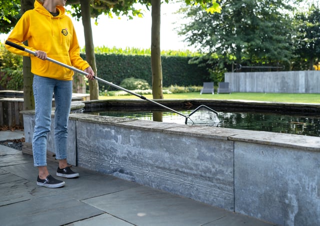 Toppy-expert maakt vijver schoon met schepnet
