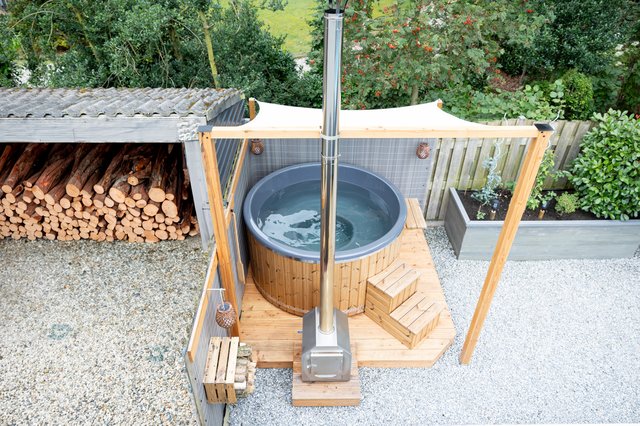 Hottub met houtkachel en houtstapel